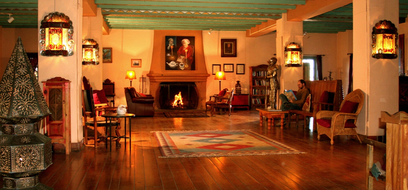 photo of La Posada interior, inviting with a fireplace and man on a couch reading a book